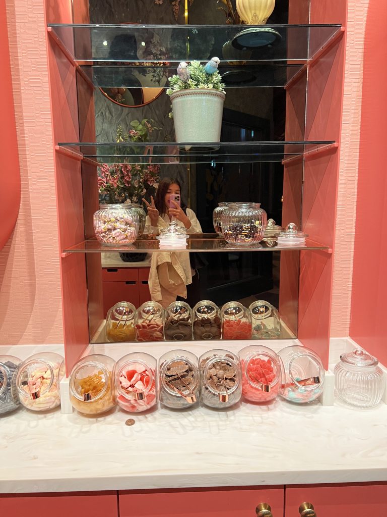 Girl posing infront of candybuffé and a mirror.