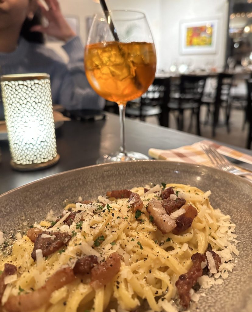 En bild på pasta carbonara i en restaurang i Amsterdam med dryck