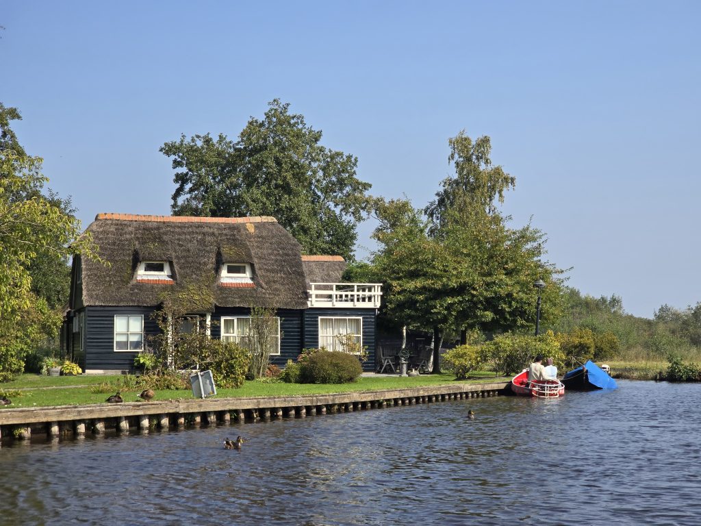 thatched-roof cottage next to canal