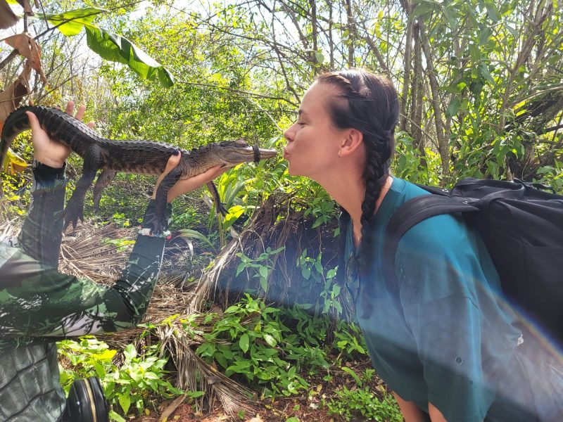 Annmari pussar en bebis alligator nästan på nosen.