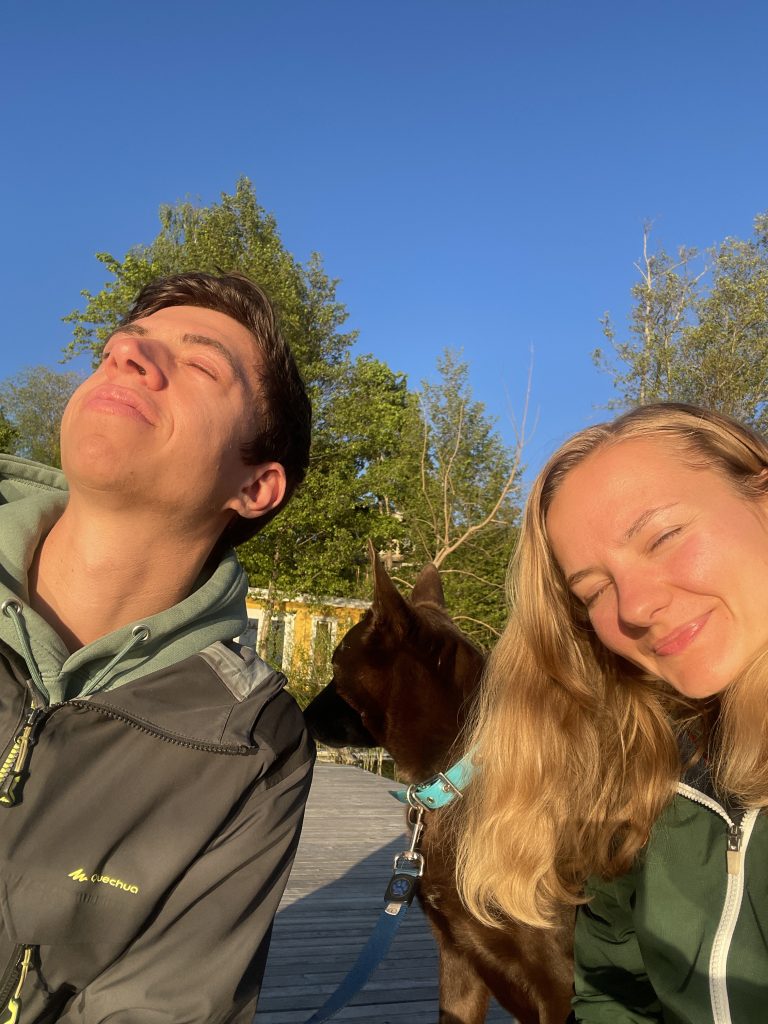 Our family. Me, my boyfriend and dog sitting on a dock in the sun in Sweden. 