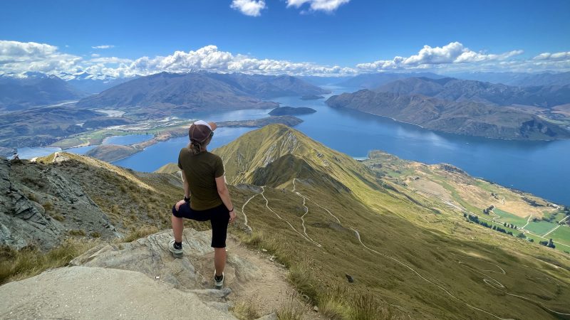 Denny on the south island of New Zealand on top of a mountain with mountain and lake views