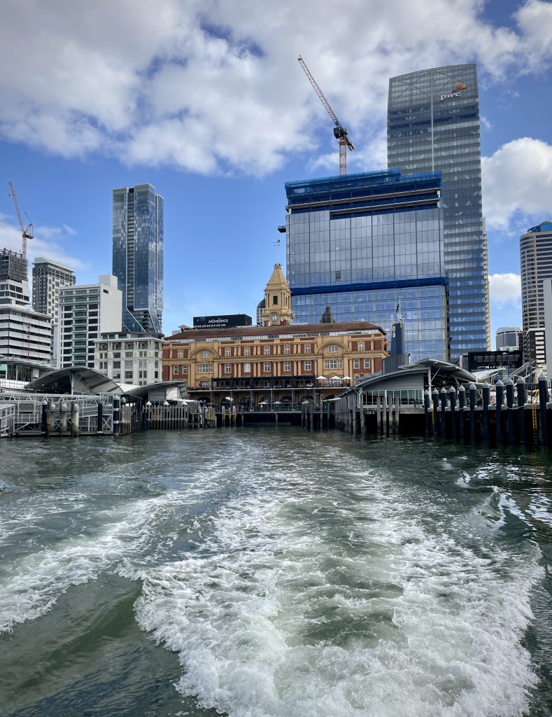 The high buildings of Auckland CBD viewed from a ferry across the sea