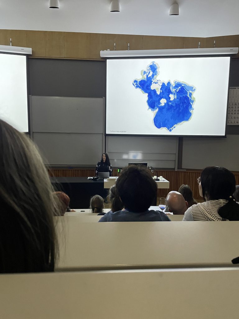 a keynote speaker in a lecture hall giving a talk about whales. 