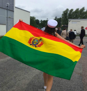 Bolivias flagga framför en skolgård. 
