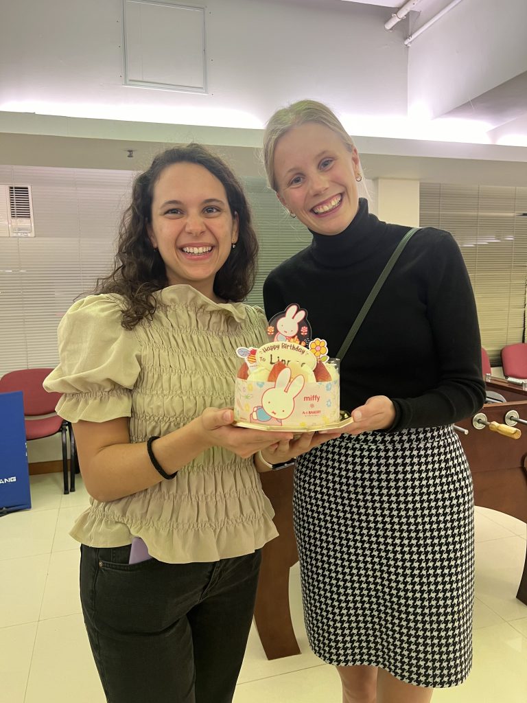 Two girls posing with a birthday cake