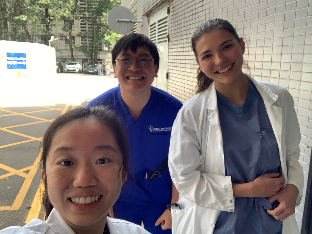 Three people in scrubs smiling for the camera during a selfie