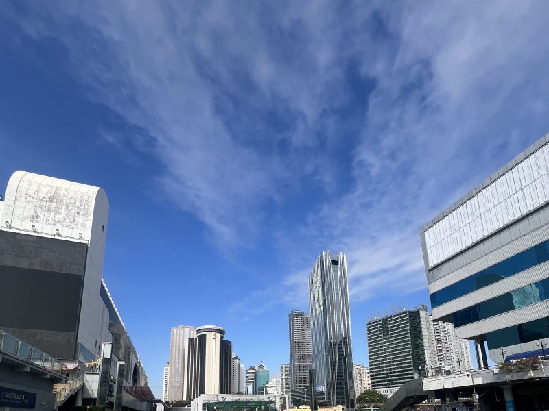 The skyline of Shenzhen from the Huo Hu Coach Station, a blue sky with some white clouds and skyscrapers in the background.