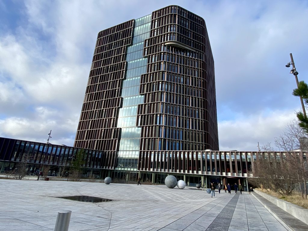 En stor och modern campusbyggnad med ett högt torn
