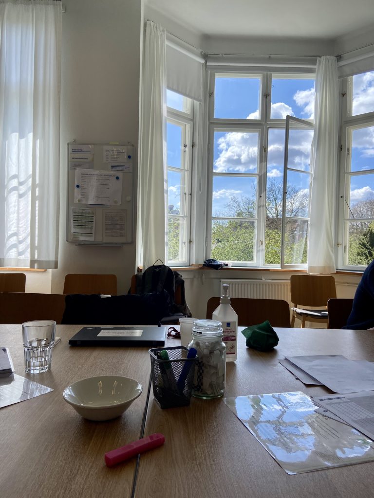 Konferensrum med bord, stolar och fönster med blå himmel utanför