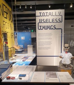 Display of objects in glass cases with an informational poster behind them.
