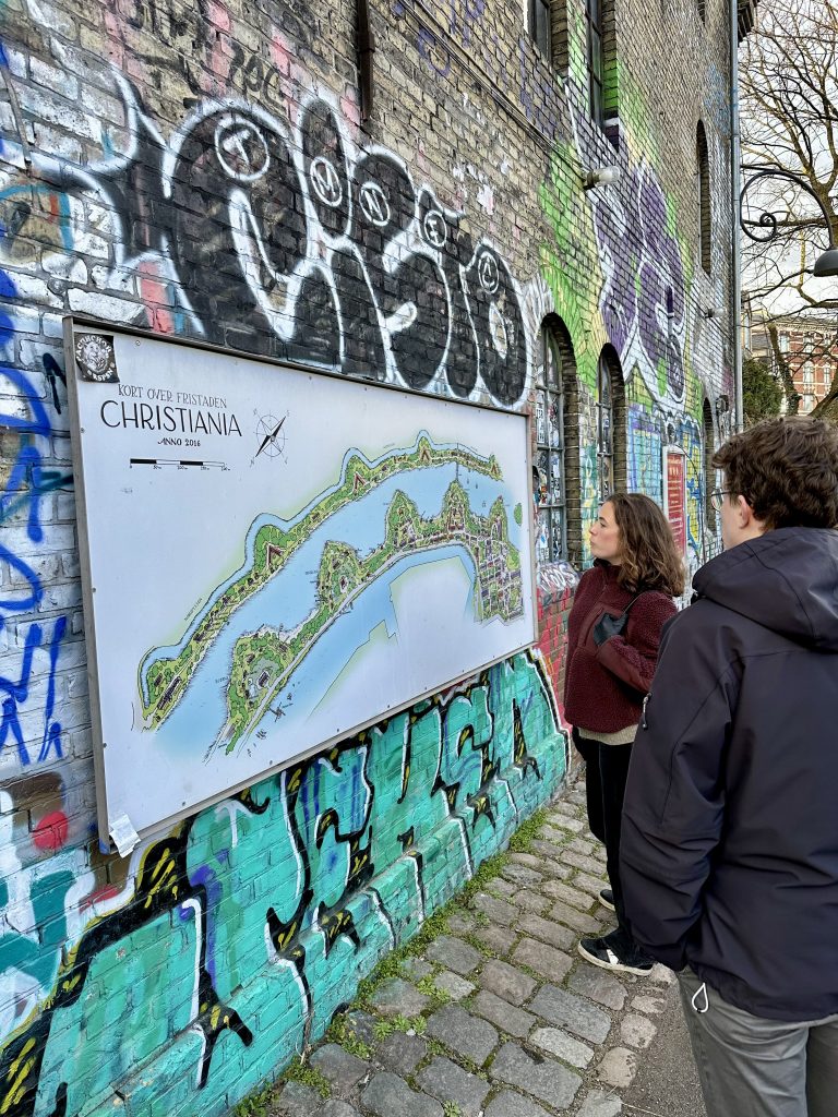 Vid en karta över området Christiania, uppsatt på en grafittimålad vägg