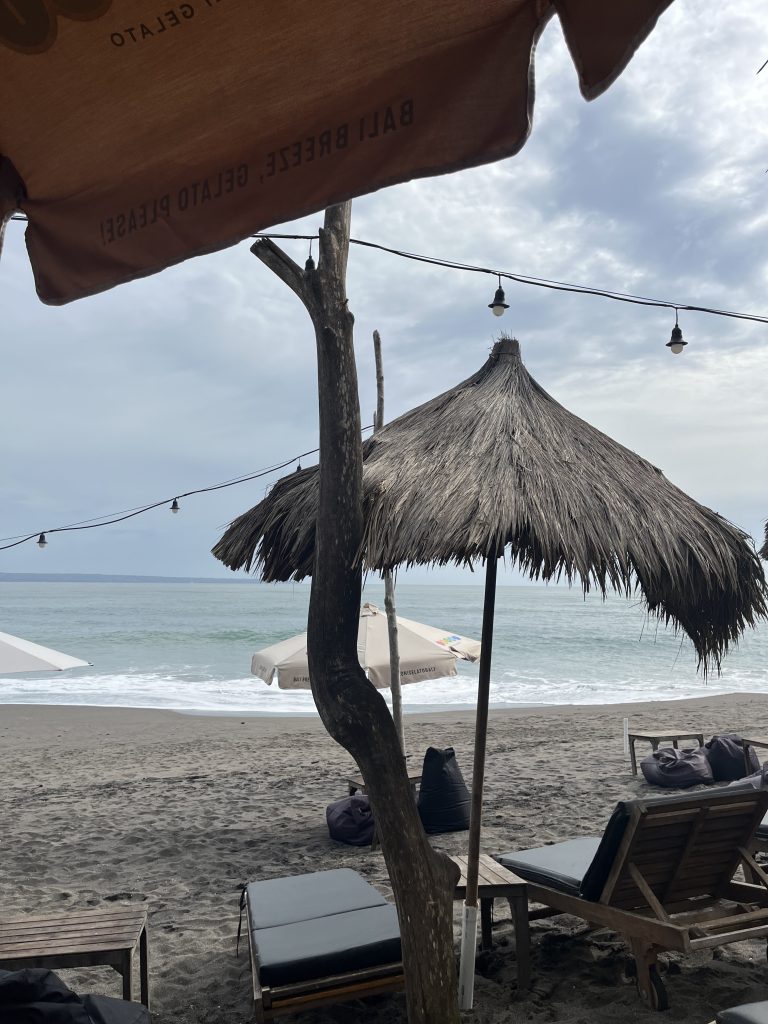 Bild på stranden med parasol i vägen.