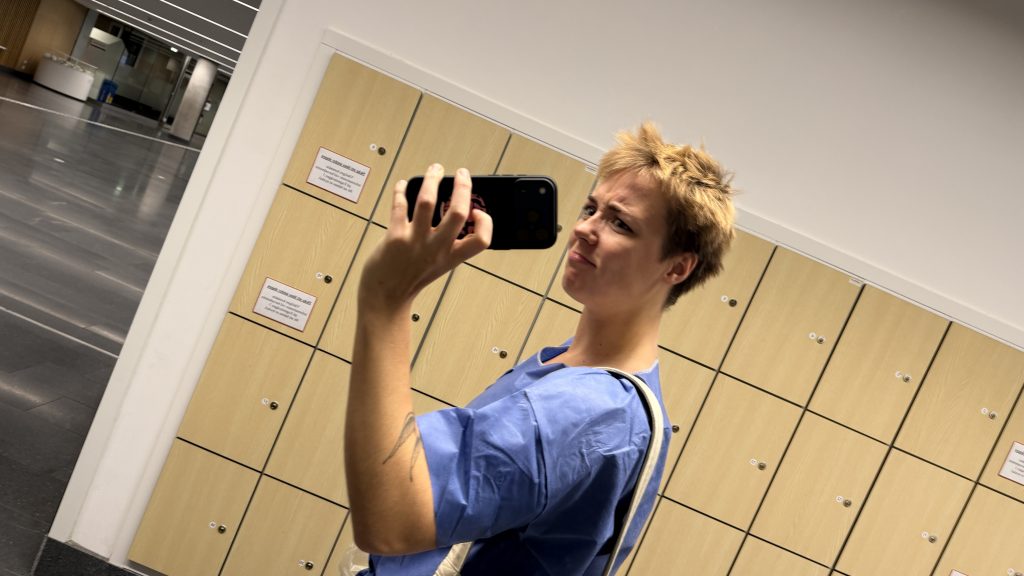 Bild: en selfie på mig i engångsscrubs. Foto: Malin Andrée