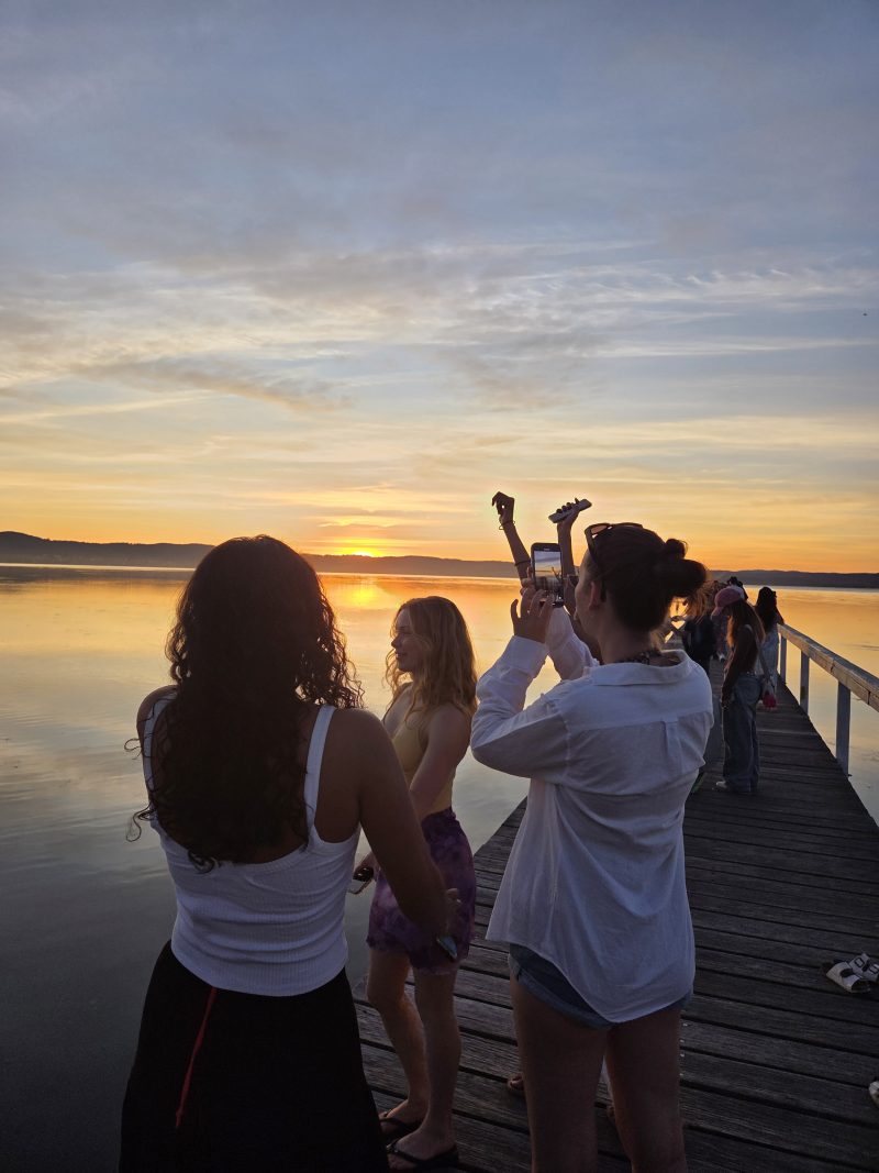 Tjejer på brygga i solnedgången